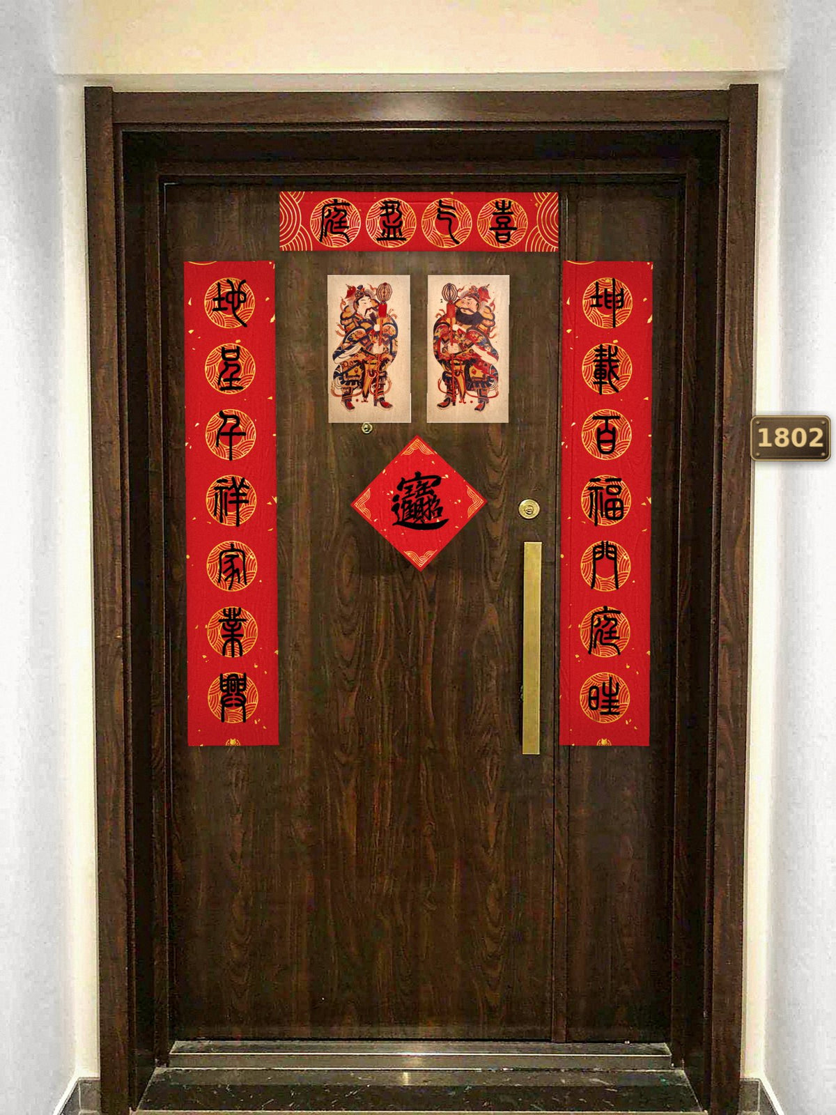 The whole set on a front door: the couplets either side, the lintel banner above, the door gods and the 招财进宝 square between them
